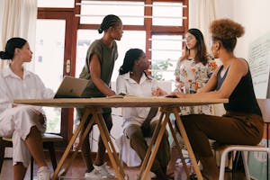 A diverse team of women brainstorming ideas in a modern office setting, fostering collaboration and creativity.