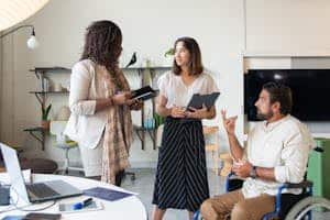 A diverse team collaborating on a project indoors, promoting inclusiveness and teamwork.
