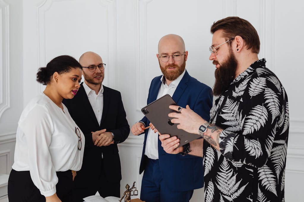 Group of diverse professionals collaborating in an office with tablet and documents.