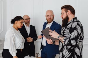 Group of diverse professionals collaborating in an office with tablet and documents.