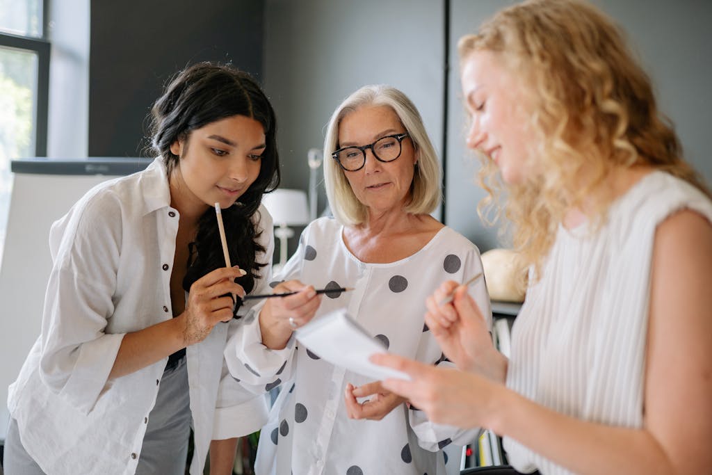 A diverse team of women engaged in a productive office meeting, working together with focus and dedication.