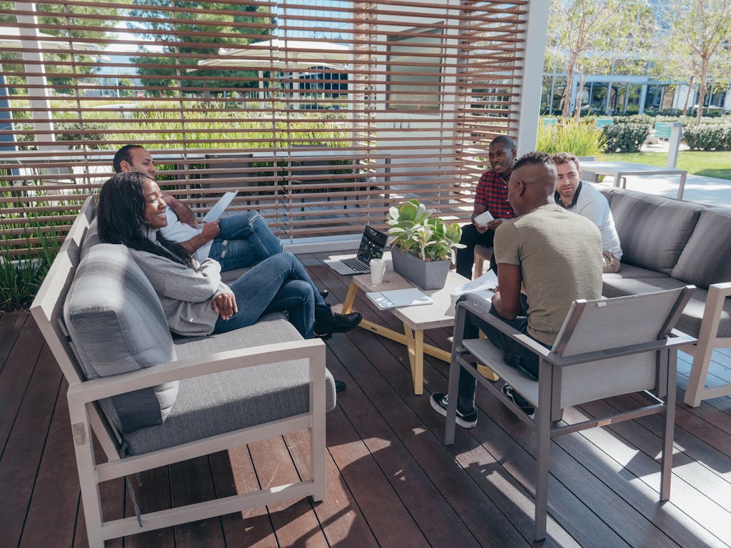 Diverse team having a collaborative meeting outdoors in a modern office setting.
